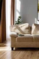 Cozy sofa with a book. The corner of the room is illuminated by the sun. Pleasant warm colors. photo