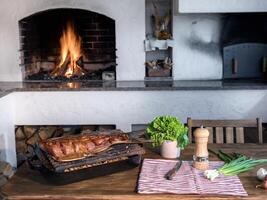 Smoked fish on a grill in front of a barbecue with fire. Fresh vegetables and appetizing fish on a wooden table. photo