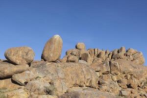 Picture of a rugged rock formation in the savannah in the south of Namibia near Fish River Canyon under a blue sky photo