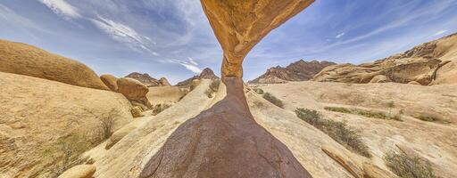 panorámico imagen de el famoso Roca arco a el Spitzkoppe en Namibia durante el día con azul cielo foto
