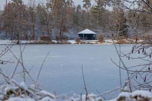 Picture of a frozen pond with wooden shelter in the morning light photo