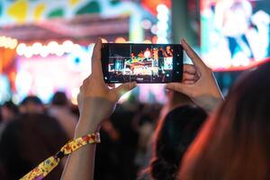 personas participación inteligente teléfono y grabación y fotografiando en música festival concierto foto