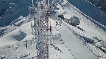 Antenne. Zelle Turm bedeckt mit Frost auf oben von ein Berg Grat video