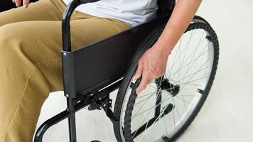 stänga upp av kvinnas hand rör på sig rullstol inomhus på Hem. kvinna är upptagen med inhemsk aktiviteter video