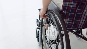 proche en haut de femme main en mouvement fauteuil roulant à l'intérieur à maison. Jeune femme est occupé avec national Activités video