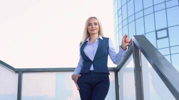 A well dressed happy office corporate 50 years female executive standing outside a modern corporate building video