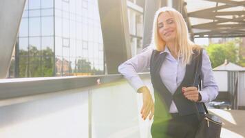 un bien vestido contento oficina corporativo 50 años hembra ejecutivo en pie fuera de un moderno corporativo edificio video