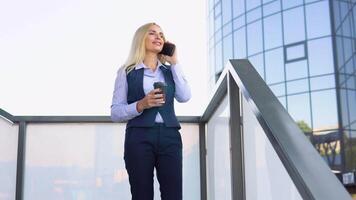 Portrait of happy 50 yearsbusiness woman calling phone outdoor. Businesswoman talking mobile phone near modern office building video