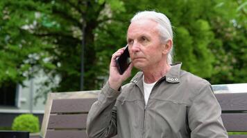 A portrait of an elderly person using a mobile phone, holding device, text messages, surfing on the internet and using the application video