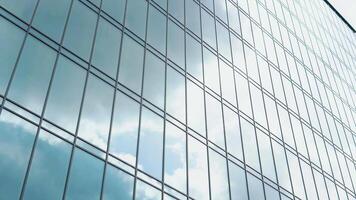 nuvole riflessa su il bicchiere di un' grande ufficio costruzione. in movimento il nuvole è riflessa su il finestre di il ufficio video