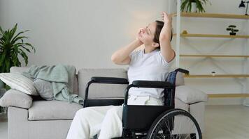 giovane donna riabilitazione nel sedia a rotelle. addestramento, sport, recupero e sollevamento, allungamento esercizio a casa video