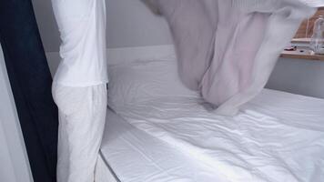 morning routines. young woman wearing pajamas making bed in the morning video