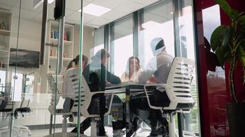 equipe líder sentado às mesa com colegas, discutindo trabalhando problemas às negociações reunião. em desenvolvimento comece marketing estratégia video