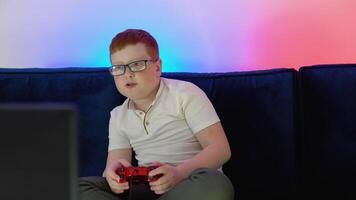 en boy-gamer leva spel strömning. liten gamer spelar spel och ser på skärm på pc dator. begrepp av digital teknologi och cyberrymden spelande. cyberpunk Färg video