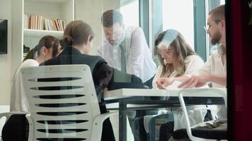 equipo líder sentado a mesa con colegas, que se discute trabajando cuestiones a negociaciones reunión. desarrollando puesta en marcha márketing estrategia video