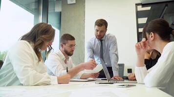 Team leader sitting at table with colleagues, discussing working issues at negotiations meeting. Developing startup marketing strategy video