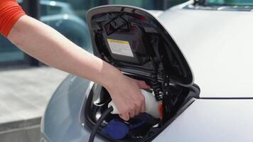 Close up view of a girls hand that cannot get the charger of her electric car video