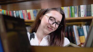 A university student is looking for a book on bookshelves in the library video