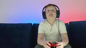 gamer diskuterar taktik med lagkamrater medan talande in i headset. stänga upp porträtt av en liten pojke spelar uppkopplad dator spel i de kväll på Hem video