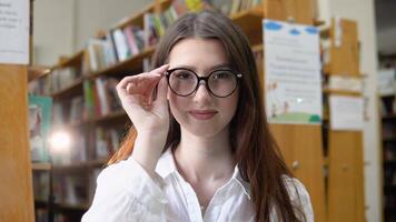 Porträt von ein schön Mädchen im Brille im das Universität Bibliothek video