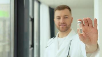 un médico sostiene un ampolla con un vacuna en su mano video