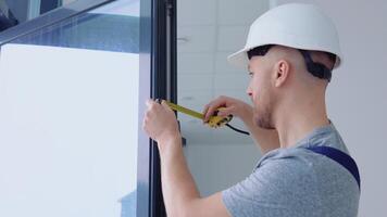 fönster installatören åtgärder de mått av de fönster ram med en meter tejp video