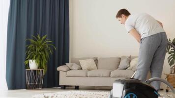 Senior woman vacuuming carpet at home. Daily routine. Cozy environment video