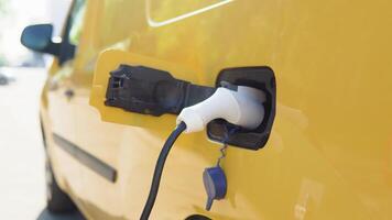 eléctrico coche cargando amarillo eléctrico coche es cargado a el cargando estación video