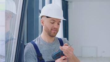 Fenster Installateur mit ein Schraubendreher steht in der Nähe von das Fenster video