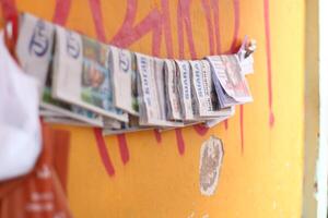 maglang, Indonesia.03 29 2024.noticias - doblada periódicos en frente de un naranja pared para venta. foto