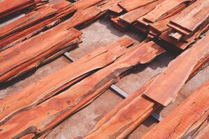 Pile of many redwood wood panels on industrial yard area, wood construction material background photo