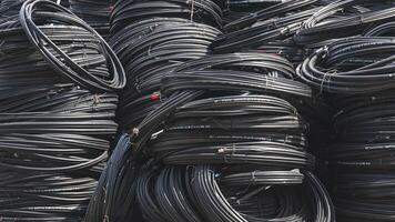 Various sizes of many black fiber optic cable lines stacked in a big pile. photo