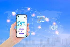 Man hand holding smartphone with Internet of things word on screen and icons connecting together, internet networking system concept photo