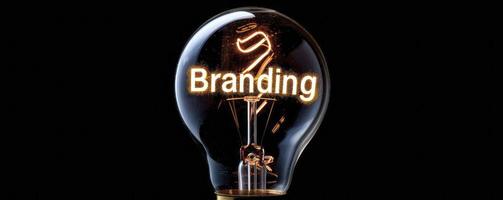 A light bulb with glowing wire forming the word Branding on a black background. photo