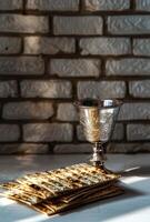 Matzah and a silver goblet on a white table, photo