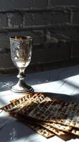 Matzah and a silver goblet on a white table, photo