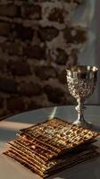 Matzah and a silver goblet on a white table, photo