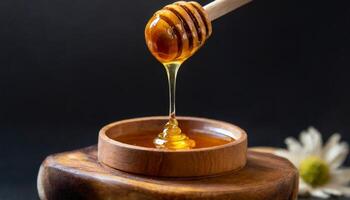 Macro shot of honey dripping from honey dipper photo