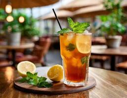 Cold Iced tea with lemon and mint on the table with blurred background photo