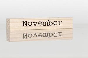 wooden cube with the inscription November on a white background photo