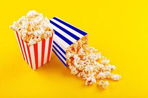 Glass with popcorn on a yellow background photo