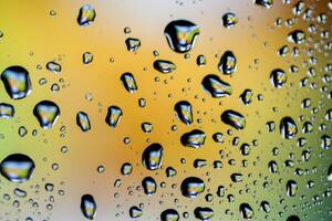 Beautiful multi-colored water droplets on a glass photo