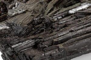 Macro stone black mineral tourmaline Scherl on white background photo