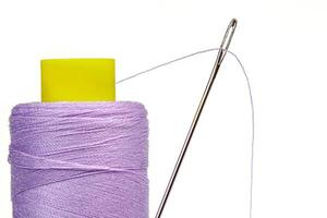 Macro skein of thread purple colors with a needle on a white background photo