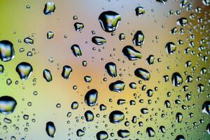 Beautiful multi-colored water droplets on a glass photo