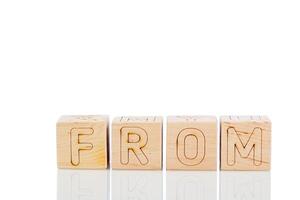 Wooden cubes with letters from on a white background photo