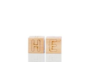 Wooden cubes with letters he on a white background photo