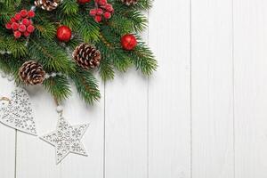 Christmas composition, Christmas tree branch with toys, cones on a wooden background photo