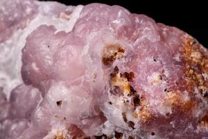 Macro pink Smithsonite mineral stone on microcline on black background photo