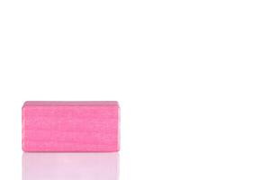 Wooden cube of pink color on a white background photo